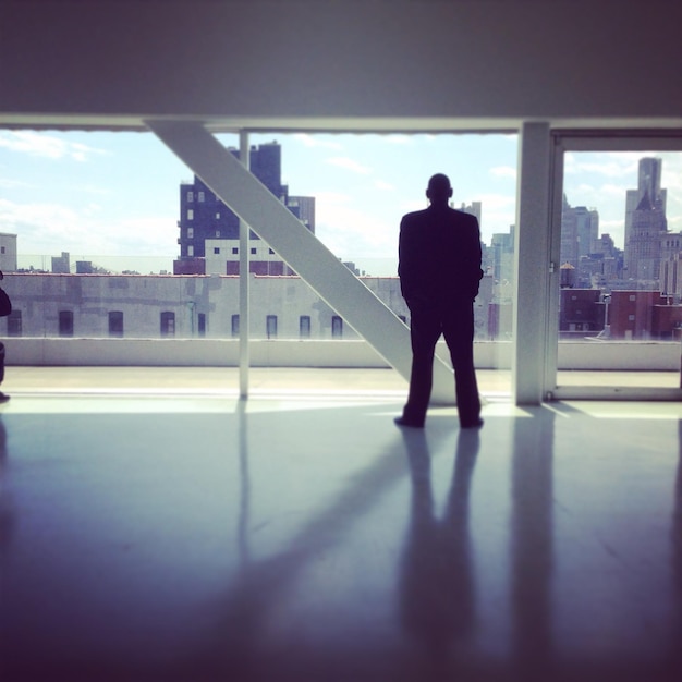 Photo longueur complète de l'homme de silhouette debout dans la ville contre le ciel