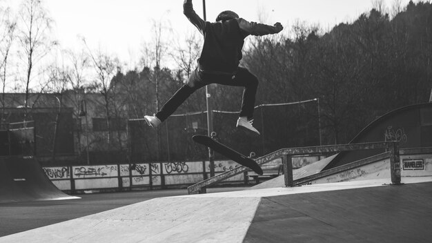 Photo longueur complète d'un homme en skateboard dans un parc de skateboard