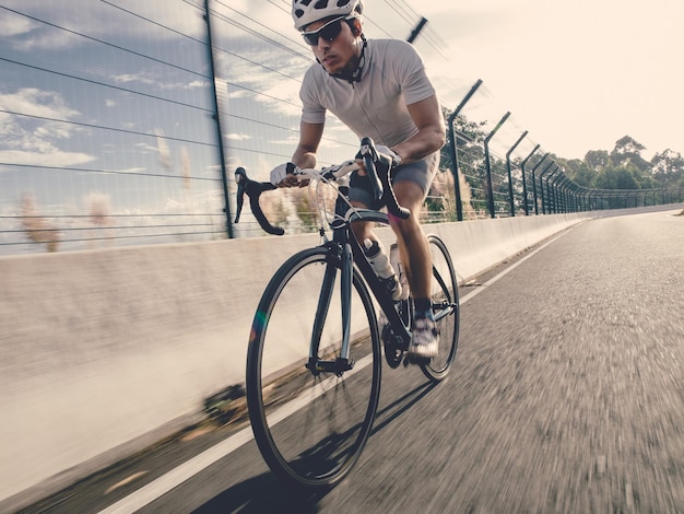 Longueur complète de l'homme à vélo sur la route par balustrade