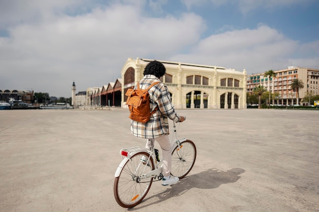 Une longueur complète d'un touriste sur son véhicule de location respectueux de l'environnement sur la place de la ville