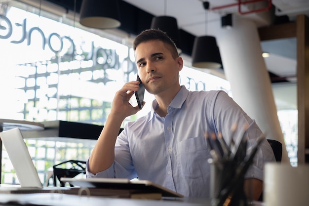 Lorsqu'il lui propose le grand projet, un homme d'affaires américain sérieux attend la confirmation de son partenaire par téléphone portable.