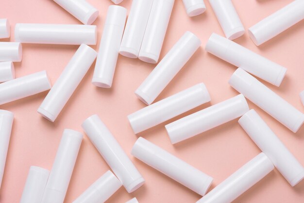 Lot de tubes de brillant à lèvres en plastique blanc sur fond rose