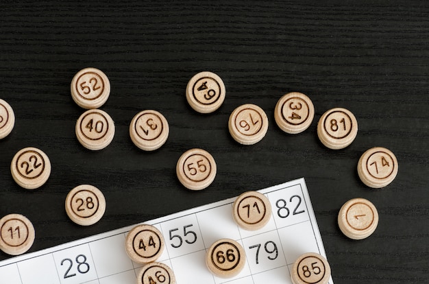 Loto en bois et carte pour jouer sur une table noire