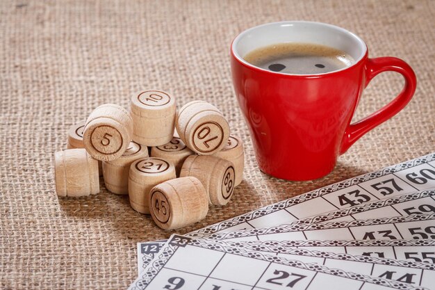 Loto de jeu de société sur un sac. Barils de loto en bois et cartes de jeu pour un jeu de loto avec une tasse de café