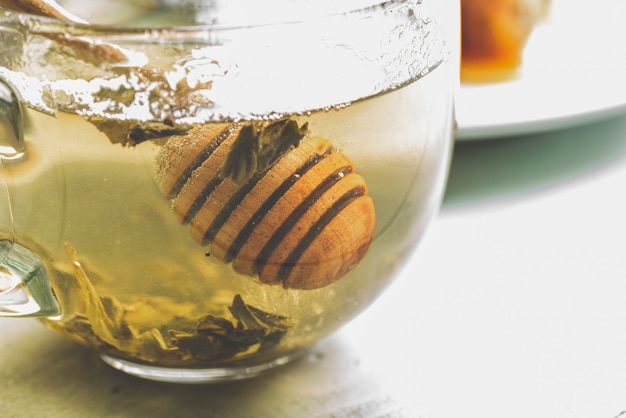 Louche de miel dans une tasse de thé vert