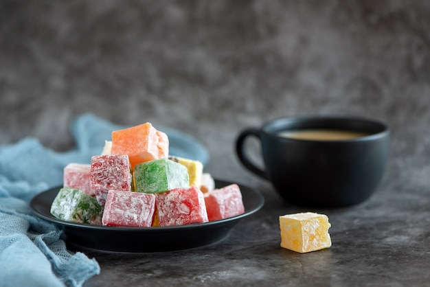 Loukoum et tasse de café sur fond gris.