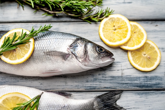 Loup de mer de poisson frais. Poisson cru au bar avec ingrédients épices et herbes sur fond de bois