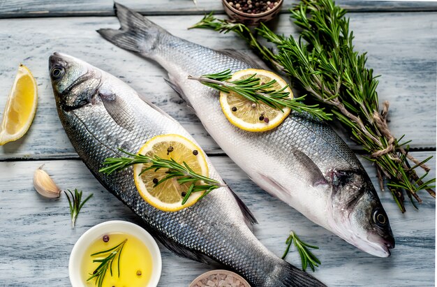 Loup de mer de poisson frais. Poisson cru au bar avec ingrédients épices et herbes sur fond de bois