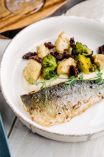 Loup de mer avec sauce crémeuse au citron et légumes chou-fleur brocoli tomates séchées