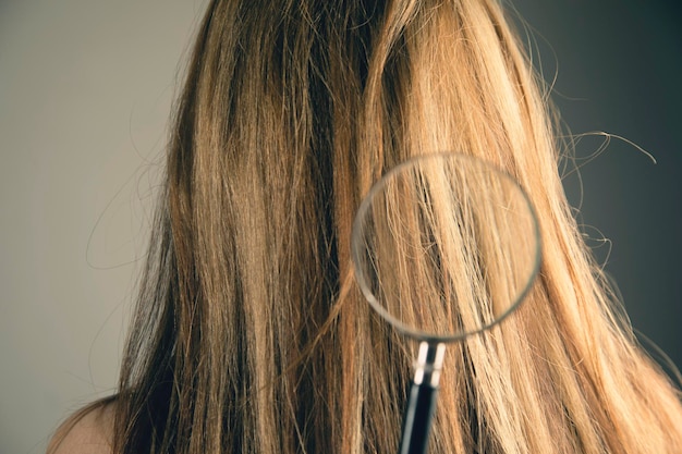 La loupe examine les cheveux d'une jeune femme