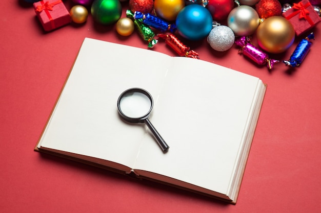 Loupe et livre près des jouets de Noël.