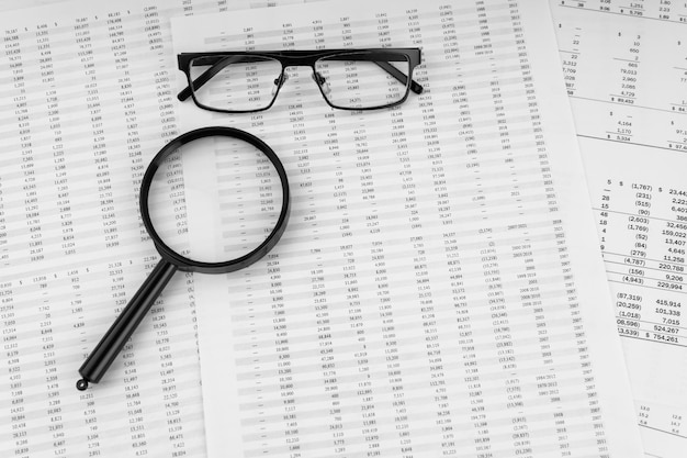 Loupe et lunettes sur les documents financiers