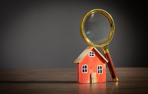 Loupe avec un modèle de maison Inspection immobilière