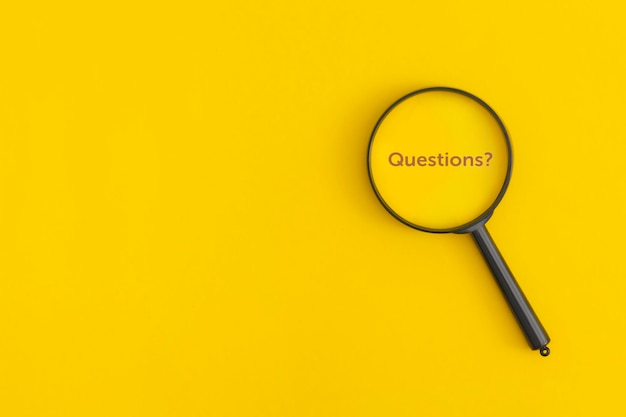 Loupe avec le mot Questions sur fond jaune