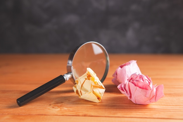 Loupe et papiers froissés sur la table