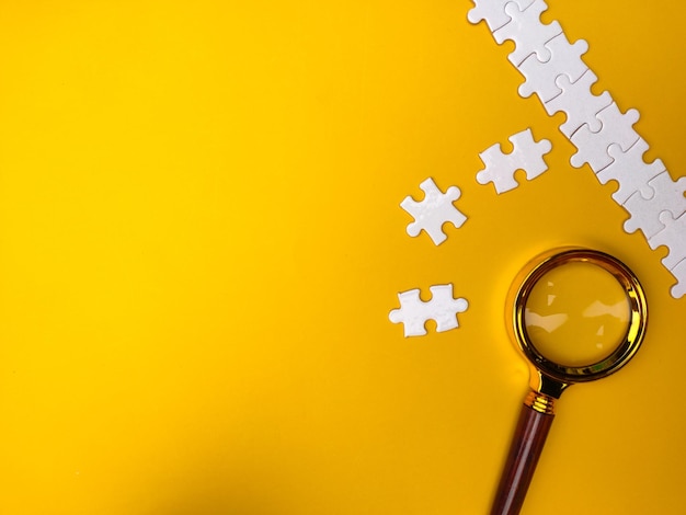 Loupe à la recherche de puzzle manquant sur fond jaune