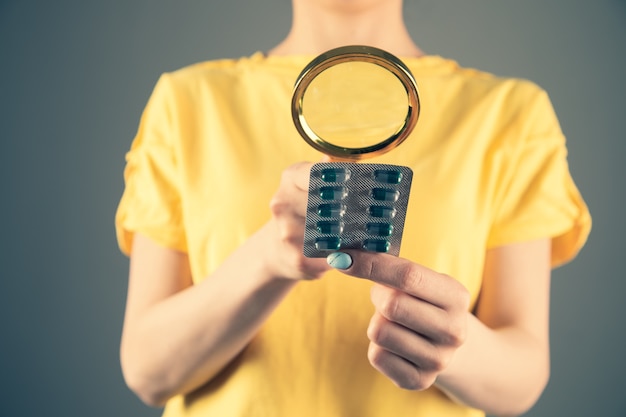 La loupe regarde les pilules. Etude et recherche de médicaments