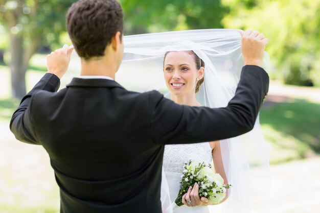 Loving groom soulevant le voile de la mariée