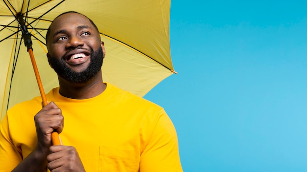 Photo low angle man holding parapluie