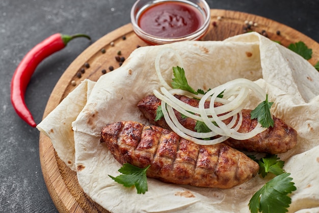 Lula kebab avec du pain pita sur une planche de bois