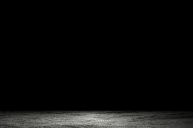 La lumière brille sur le sol en ciment gris sale dans une pièce sombre avec un fond abstrait d'espace de copie