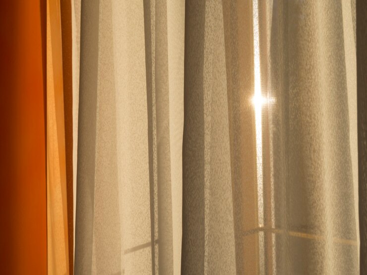 La lumière du soleil du matin passant à travers un épais rideau de fenêtre