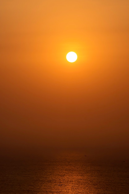 La lumière du soleil du matin reflète la mer et les bateaux de pêche.