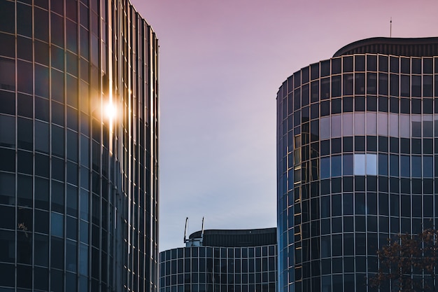 La lumière du soleil se reflétant sur la façade en verre incurvé d'un immeuble de bureaux