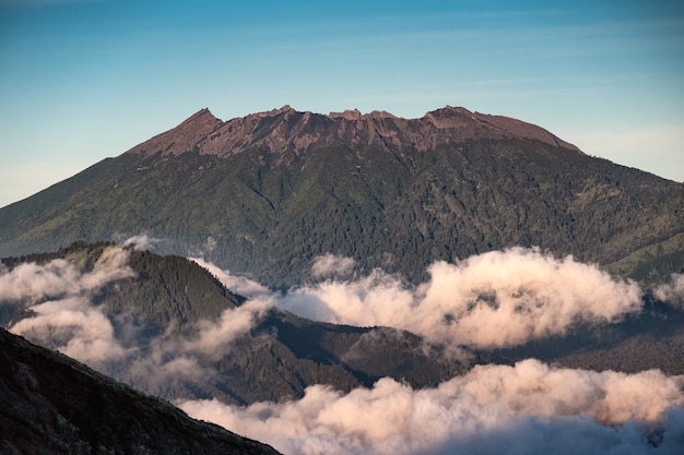 La lumière du soleil sur le volcan de pointe avec du brouillard le matin à Kawah Ijen