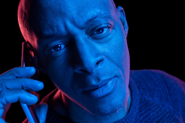 lumières bleues et rouges d'un homme noir avec téléphone intelligent