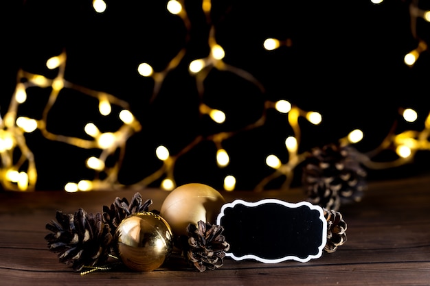 Photo lumières floues sur fond noir avec des boules de noël et des pommes de pin