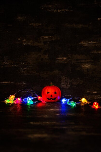 Photo lumières illuminées multicolores par la figurine de jack o'lantern pendant halloween