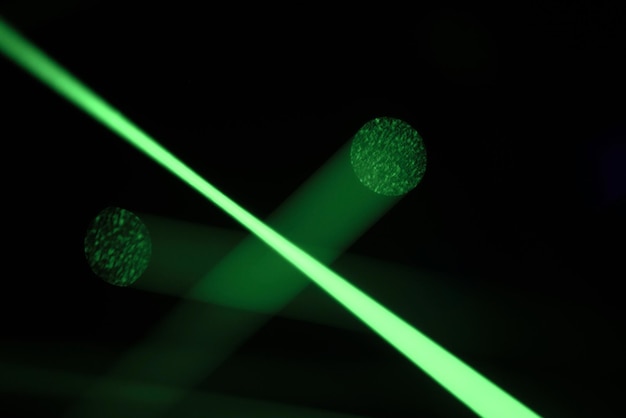 Des lumières laser au néon vert vif illuminent l'obscurité en créant des lignes