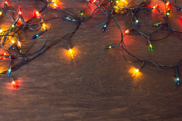 Lumières de Noël colorées sur bois sombre
