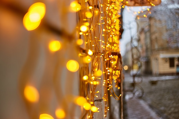Lumières de Noël dans la vieille ville et neige sur les branches de sapin. Lviv, Ukraine. Décorations de Noël dans la rue