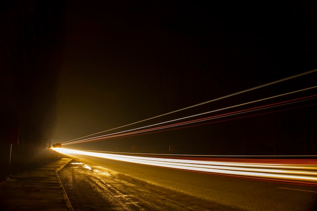 Lumières rouges et blanches des voitures qui passent. Autoroute de nuit.