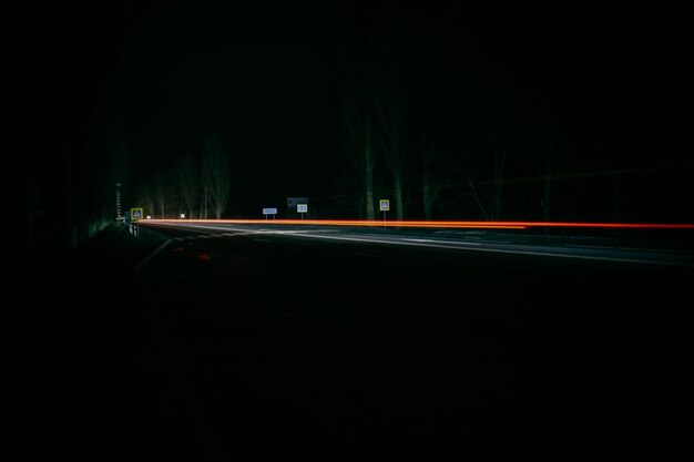 Lumières rouges et blanches des voitures qui passent. Autoroute de nuit.