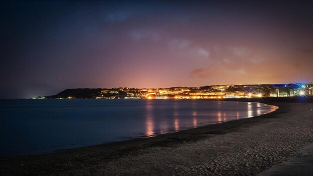 Photo les lumières de la ville et le ciel nocturne de la plage de sandsfoot dans le dorset, au royaume-uni