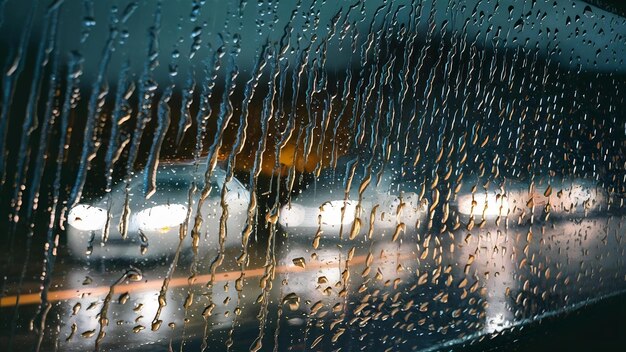 Lumières de voiture mouillées floues de l'intérieur d'une voiture