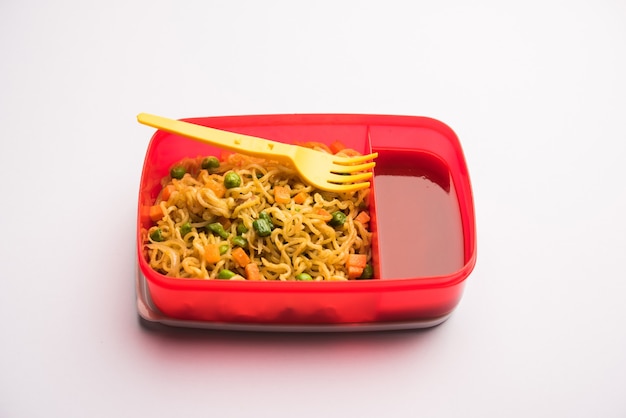 Lunch Box ou Tiffin pour les enfants indiens, contient des nouilles chaudes avec des légumes frais ainsi que du ketchup à la tomate. mise au point sélective