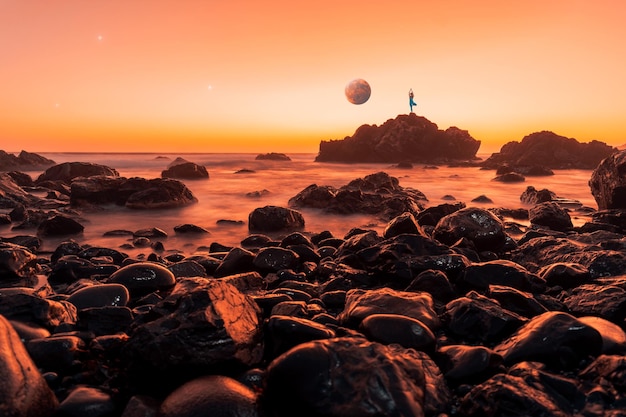 Lune au-dessus de l'océan et silhouette d'une femme en position de yoga sur un rocher à l'horizon