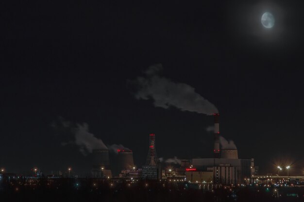 Lune la nuit au-dessus d'une centrale thermique