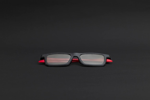 Lunettes de cinéma noires avec oreilles rouges sur fond noir