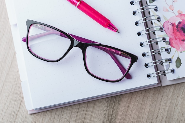 Lunettes de femme avec agenda et crayons