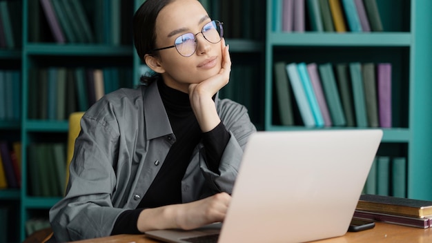 Lunettes de femme économiste sur le visage travail bureau élégant utilise un rapport d'ordinateur portable à une entreprise indépendante