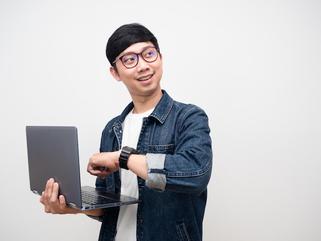 Lunettes de jeune homme d'affaires tenant un ordinateur portable montrent le sourire regardant l'espace de copie