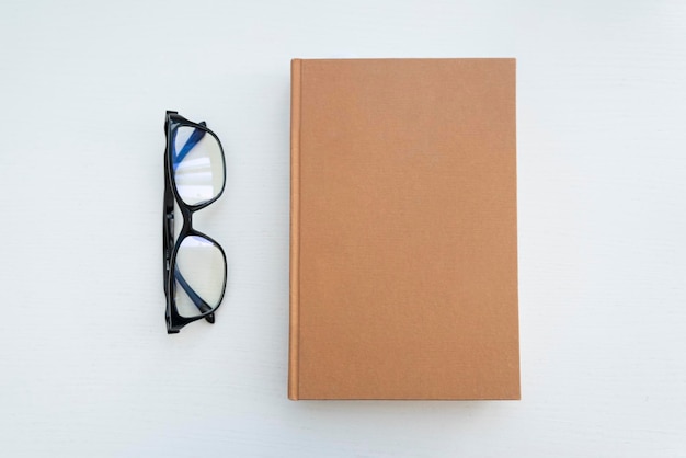 Lunettes de lecture avec livres sur la table blanche Espace vide sur la couverture pour le design et le texte