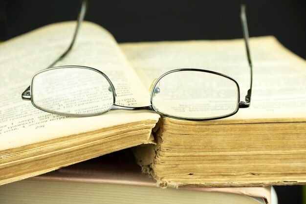 Des lunettes de lecture noires se trouvent sur un livre ouvert