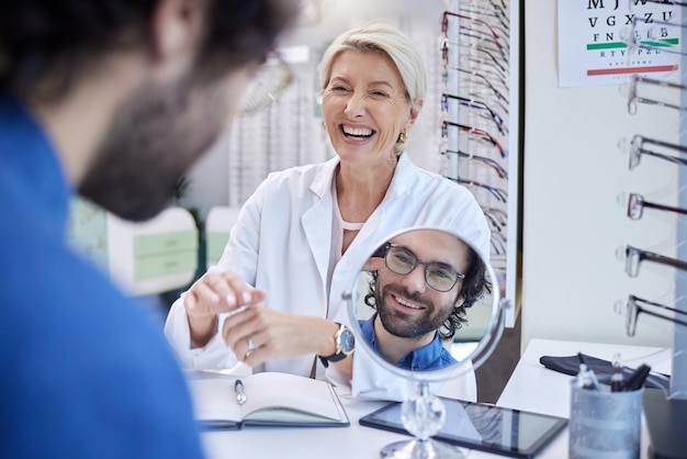 Lunettes miroir ou homme heureux consultant un médecin pour obtenir des conseils professionnels sur la vue dans un magasin de détail Client vérifiant la santé visuelle avec un opticien ou un ophtalmologiste senior de confiance