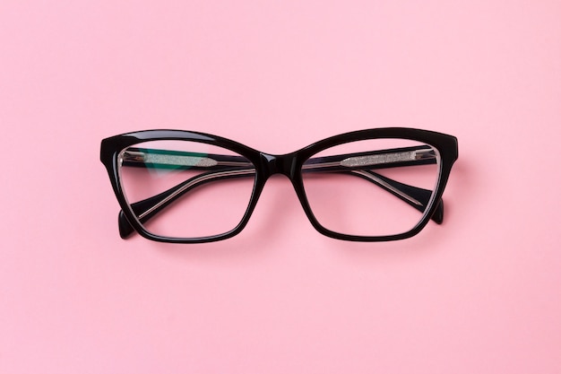 Lunettes à la mode élégantes sur une table rose créative.